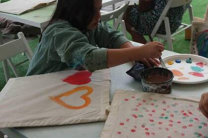 Freiwilligenarbeit in der Kunsttherapie - Kind bemalt Stofftasche